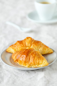 Frische Croissants auf einem hell gedeckten Frühstückstisch Frische Croissants auf einem hell gedeckten Frühstückstisch